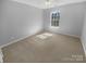 Bright bedroom with neutral carpet and paint; large window providing ample natural light at 9144 Cameron Wood Dr, Charlotte, NC 28210