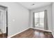 Bright bedroom with hardwood floors, a window with blinds, and neutral-colored walls at 10663 Hill Point Ct, Charlotte, NC 28262