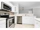 Modern kitchen with stainless steel appliances, white cabinetry, and decorative backsplash at 10663 Hill Point Ct, Charlotte, NC 28262
