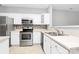 Stylish kitchen featuring stainless steel appliances, white cabinets, and tile backsplash at 10663 Hill Point Ct, Charlotte, NC 28262