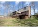 Exterior of house featuring a deck, sunroom, chimney, and wooded backyard at 107 Grand Canyon Rd, Stanley, NC 28164