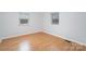 Simple bedroom featuring wood floors, two windows, and electrical outlets at 107 Grand Canyon Rd, Stanley, NC 28164