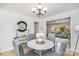 Dining room featuring a white table, gray chairs, hardwood floors, and modern lighting at 107 Grand Canyon Rd, Stanley, NC 28164