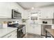 Bright kitchen features stainless steel appliances, white cabinets, and speckled quartz countertops at 107 Grand Canyon Rd, Stanley, NC 28164