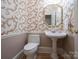 Elegant powder room featuring patterned wallpaper, pedestal sink, and an ornate gold-framed mirror at 110 49Th Avenue Nw Pl, Hickory, NC 28601