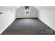 Bright bonus room featuring neutral walls, plush carpet, and a window showcasing neighborhood views at 1144 Amberlight Cir, Salisbury, NC 28144
