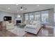 Bright living room with fireplace, ceiling fan, large windows, wood flooring, and comfortable seating arrangements at 11524 Sweet Birch Ln, Charlotte, NC 28278