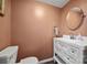 Powder room with white vanity, a decorative mirror, and a toilet on a dark wood floor at 121 N Congress St, York, SC 29745