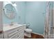 Bright bathroom with a toilet, vanity, mirror, and a shower with a decorative curtain at 121 N Congress St, York, SC 29745