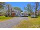 Expansive two-story home with a gravel driveway and white siding surrounded by beautiful trees at 121 N Congress St, York, SC 29745