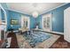 Bright blue living room with a decorative rug, chandelier, and plenty of natural light from large windows, perfect for relaxing at 121 N Congress St, York, SC 29745