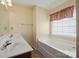 Bright bathroom featuring a double sink vanity and a tub with window at 1219 Catawba Run Rd, Lowell, NC 28098