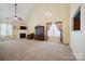 Bright living room with fireplace, ceiling fan, large windows, and neutral carpet, ideal for relaxation at 1219 Catawba Run Rd, Lowell, NC 28098