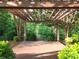 Outdoor deck area with pergola providing shade, overlooking landscaped greenery and walkway at 1219 Catawba Run Rd, Lowell, NC 28098