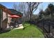 Expansive backyard view showcasing a patio with seating and a wrought iron fence, enhancing privacy at 13008 Ginovanni Way, Mint Hill, NC 28227