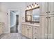 The primary bathroom has granite countertops, and cream colored cabinets, and a decorative mirror at 13008 Ginovanni Way, Mint Hill, NC 28227