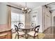 A cozy dining area with chandelier, round table, large window and doorway with access to the kitchen at 13008 Ginovanni Way, Mint Hill, NC 28227