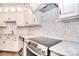 Bright kitchen with herringbone backsplash, white cabinets, stainless steel appliances, and granite countertops at 13008 Ginovanni Way, Mint Hill, NC 28227