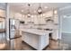 Bright kitchen with stainless steel appliances, pendant lighting, white cabinets, granite countertops, and a central island at 13008 Ginovanni Way, Mint Hill, NC 28227
