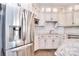 A modern kitchen features stainless steel refrigerator, white cabinets and a herringbone tile backsplash at 13008 Ginovanni Way, Mint Hill, NC 28227