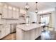 Bright kitchen with stainless steel appliances, white cabinets, granite countertops, and a central island next to dining area at 13008 Ginovanni Way, Mint Hill, NC 28227