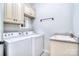 Functional laundry room with washer, dryer, sink, granite countertop and ample cabinet space at 13008 Ginovanni Way, Mint Hill, NC 28227