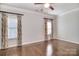 A spacious bedroom featuring hardwood floors, large windows, blinds, and decorative curtains at 13008 Ginovanni Way, Mint Hill, NC 28227