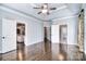 Spacious main bedroom featuring hardwood floors, tray ceilings, a ceiling fan, and ensuite access at 13008 Ginovanni Way, Mint Hill, NC 28227