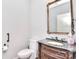 Powder room features a ornate vanity, bronze faucet, grey marble countertop, mirror, and decorative tissue box at 13008 Ginovanni Way, Mint Hill, NC 28227
