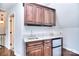 Wet bar featuring granite countertop, cabinetry, sink, and mini fridge for added convenience at 13008 Ginovanni Way, Mint Hill, NC 28227