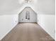 Finished attic space with neutral carpet, a window, and slanted ceilings, suitable for storage or a bonus room at 1442 Rainforest Ct, Gastonia, NC 28054