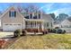 Charming home featuring a manicured lawn, dormer windows, shutters and a inviting covered front porch at 1442 Rainforest Ct, Gastonia, NC 28054