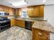 Well-lit kitchen with stainless steel appliances, granite countertops, tile floors, and wood cabinets at 1442 Rainforest Ct, Gastonia, NC 28054