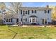 Backyard view of a two-story home with a spacious patio and mature trees at 1448 Morrocroft Trl, Gastonia, NC 28054