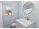 Well-lit bathroom with a modern vanity, round mirror, and a window for natural light at 1448 Morrocroft Trl, Gastonia, NC 28054
