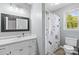 Clean bathroom features a single sink vanity, floral shower curtain, and a window for natural light at 1448 Morrocroft Trl, Gastonia, NC 28054