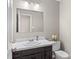 Cozy powder room featuring a dark vanity and large mirror with modern fixtures at 1448 Morrocroft Trl, Gastonia, NC 28054