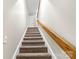 Carpeted staircase with wood railing leads to the upper level of the home at 1448 Morrocroft Trl, Gastonia, NC 28054