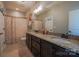 Double sink bathroom with granite countertops, tiled floors, and dark cabinets at 15125 Skypark Dr, Huntersville, NC 28078