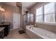 Bathroom with a large tub, a separate shower, and a granite countertop that complements the neutral color scheme at 15125 Skypark Dr, Huntersville, NC 28078