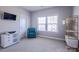 Cozy bedroom featuring neutral carpet, a blue chair, a storage unit, a window, and an accent wall at 15125 Skypark Dr, Huntersville, NC 28078