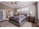 Elegant bedroom suite featuring a tray ceiling, a plush bed, and an ensuite bathroom for a private retreat at 15125 Skypark Dr, Huntersville, NC 28078