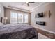 Inviting bedroom with a modern electric fireplace, tray ceiling, and bright windows for natural light at 15125 Skypark Dr, Huntersville, NC 28078