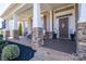 Covered front porch with stone pillars, front door, and manicured landscaping at 15125 Skypark Dr, Huntersville, NC 28078