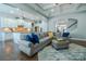 Open-concept living area featuring a spacious sectional, modern kitchen, and seamless entertaining space at 15125 Skypark Dr, Huntersville, NC 28078