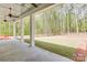 Covered patio overlooking a lush green backyard with new sod and wooded perimeter at 155 Eagle Chase Ln, Troutman, NC 28166