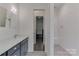 Bright bathroom featuring a vanity with dual mirrors, shower, and seamless access to the hallway at 155 Eagle Chase Ln, Troutman, NC 28166