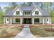 Beautiful craftsman home boasts a manicured lawn, covered porch, and stone accents at 155 Eagle Chase Ln, Troutman, NC 28166