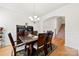 Traditional dining room features hardwood floors, wainscoting, a stylish chandelier and seating for six at 15916 Foreleigh Rd, Huntersville, NC 28078