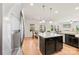 Open-concept kitchen with stainless steel appliances, a granite island and seamless transition to the dining and living areas at 15916 Foreleigh Rd, Huntersville, NC 28078